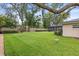 Well-manicured backyard with swing, green grass, mature trees, privacy fence, and screened-in pool area at 708 Valencia Ct, Winter Garden, FL 34787