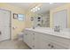 Bathroom featuring double vanity with white cabinets and large mirror at 708 Valencia Ct, Winter Garden, FL 34787
