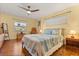 Cozy bedroom with hardwood floors, a ceiling fan, and natural light from two windows at 708 Valencia Ct, Winter Garden, FL 34787