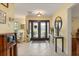 Bright foyer with tile flooring, statement mirror, and beautiful double door entryway that welcomes guests at 708 Valencia Ct, Winter Garden, FL 34787