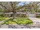 Charming single story home featuring a lush front yard with a well manicured lawn, mature tree, and inviting covered porch at 708 Valencia Ct, Winter Garden, FL 34787