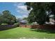 Expansive backyard with lush green grass and a traditional brick fence, and shade trees at 759 Lake Como Dr, Lake Mary, FL 32746