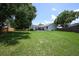 Vast backyard with green grass, trees, and partial view of the home's rear exterior at 759 Lake Como Dr, Lake Mary, FL 32746