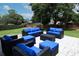 Spacious backyard featuring a charming blue cushioned patio set, green grass, and brick fencing at 759 Lake Como Dr, Lake Mary, FL 32746