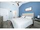 Comfortable bedroom boasts a blue accent wall, ceiling fan, and ensuite access for a relaxing retreat at 759 Lake Como Dr, Lake Mary, FL 32746