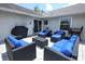 Charming patio with ample blue cushioned seating, grill and tasteful outdoor decor at 759 Lake Como Dr, Lake Mary, FL 32746