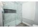 Beautiful walk-in shower features marble tiling, a built-in niche and modern fixtures at 759 Lake Como Dr, Lake Mary, FL 32746