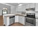 Kitchen featuring white cabinets, stainless steel appliances, breakfast bar and open layout at 845 Valnera Ct, Kissimmee, FL 34758