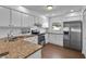 Well-lit kitchen with white cabinets, granite counters, stainless steel appliances and hardwood floors at 845 Valnera Ct, Kissimmee, FL 34758
