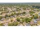 Wide aerial shot of suburban neighborhood with mature trees, homes, and tree-lined streets at 879 Tamerlane St, Deltona, FL 32725