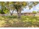 Spacious backyard featuring mature trees, a well-maintained lawn, and home exterior at 879 Tamerlane St, Deltona, FL 32725