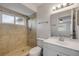 Bathroom featuring a stand-up shower, a bright vanity, and a large mirror with views of the bedroom at 879 Tamerlane St, Deltona, FL 32725