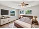 Well-lit bedroom featuring a ceiling fan, a modern bed frame, and many windows with outside views at 879 Tamerlane St, Deltona, FL 32725
