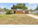 Charming single-story home featuring unique wood accents, a well-maintained lawn, and attached garage at 879 Tamerlane St, Deltona, FL 32725