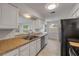 Well-lit kitchen featuring granite countertops, white cabinetry, stainless steel appliances, and a pass-through window at 879 Tamerlane St, Deltona, FL 32725