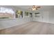 Living room with neutral carpeting, a ceiling fan, many windows, and a white entry door at 879 Tamerlane St, Deltona, FL 32725