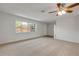 Sunlit living room featuring neutral walls, carpet, and a ceiling fan, creating a bright and airy feel at 879 Tamerlane St, Deltona, FL 32725