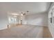 Spacious living area filled with natural light, neutral carpet, and view of the dining and kitchen areas at 879 Tamerlane St, Deltona, FL 32725