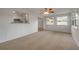 Bright living room featuring neutral carpet, a ceiling fan, and many windows with natural light at 879 Tamerlane St, Deltona, FL 32725