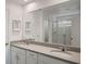 Well-lit bathroom featuring a double vanity, a large mirror, and a glass-enclosed shower at 8951 Hilton Ridge Ave, Kissimmee, FL 34747