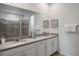 Bathroom featuring double sinks, quartz countertops, and a tiled shower at 8951 Hilton Ridge Ave, Kissimmee, FL 34747