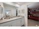 Bathroom with double sinks, a large mirror, and a bedroom entrance featuring bunk beds at 8951 Hilton Ridge Ave, Kissimmee, FL 34747