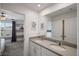 A well-lit bathroom with double sinks and a large mirror, shared with an adjacent bedroom at 8951 Hilton Ridge Ave, Kissimmee, FL 34747