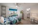 A well-lit bedroom with a window seat, colorful bedding, and a bathroom entrance at 8951 Hilton Ridge Ave, Kissimmee, FL 34747