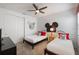 A cozy bedroom with two twin beds, Mickey Mouse decor, and carpet flooring at 8951 Hilton Ridge Ave, Kissimmee, FL 34747