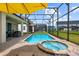 Beautiful pool and spa area with a covered patio, complete with comfortable seating and lush landscaping at 8951 Hilton Ridge Ave, Kissimmee, FL 34747