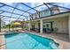 Resort-style pool with a spa, sun loungers, and covered seating for ultimate outdoor relaxation and enjoyment at 8951 Hilton Ridge Ave, Kissimmee, FL 34747