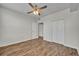 Bedroom featuring wood floors, neutral paint, ceiling fan, closet, and attached bathroom at 911 N Orange Ave # 443, Orlando, FL 32801