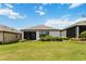Well-manicured backyard featuring lush green lawn, mature landscaping, and a screened-in lanai at 971 Braewood Dr, Clermont, FL 34715