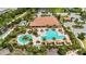 Aerial view of the community pool area showcasing ample lounge space, lush landscaping, and various pool areas at 971 Braewood Dr, Clermont, FL 34715