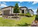 Well-manicured front yard of a modern home featuring lush green grass and carefully arranged landscaping at 971 Braewood Dr, Clermont, FL 34715