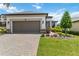 Home exterior with a large two car garage, paver driveway, and meticulously maintained front yard at 971 Braewood Dr, Clermont, FL 34715