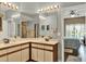 Bathroom with double sinks, modern lighting, and an entrance to the main bedroom at 11548 Pumpkin Seed Ct, Orlando, FL 32821