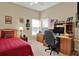Bedroom features a built-in desk, bright windows, neutral carpet and a ceiling fan at 11548 Pumpkin Seed Ct, Orlando, FL 32821