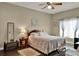 Cozy bedroom with wood floors, a ceiling fan, a patterned quilt and lots of light at 11548 Pumpkin Seed Ct, Orlando, FL 32821