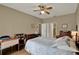 Comfortable bedroom features wood floors, neutral paint, ceiling fan, and a large bed at 11548 Pumpkin Seed Ct, Orlando, FL 32821
