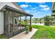 View of the screened-in lanai facing a serene lake and lush backyard at 11548 Pumpkin Seed Ct, Orlando, FL 32821