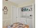 Functional laundry area with a washer, dryer, shelving, and a convenient table for folding clothes at 11548 Pumpkin Seed Ct, Orlando, FL 32821