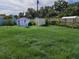 Spacious backyard with multiple storage sheds and a wooden fence at 1200 Ne 45Th Pl, Ocala, FL 34479