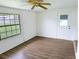 Bright bedroom with a ceiling fan, window, and stylish gray wood-look flooring at 1200 Ne 45Th Pl, Ocala, FL 34479