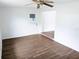 Well-lit bedroom with a ceiling fan, back door, and gray wood-look flooring at 1200 Ne 45Th Pl, Ocala, FL 34479