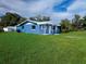 Charming blue single-story home featuring a covered porch and a well-maintained front yard at 1200 Ne 45Th Pl, Ocala, FL 34479