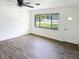 Light-filled living room showcases gray wood-look flooring, a window, and fresh, white walls at 1200 Ne 45Th Pl, Ocala, FL 34479