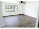 Inviting living room with a large window, white walls, and sleek gray wood-look floors at 1200 Ne 45Th Pl, Ocala, FL 34479