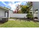 A backyard area, enclosed by a white privacy fence, featuring mature trees at 1615 Wilson Ave, Orlando, FL 32804