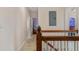 Upstairs hallway featuring wood railing and access to bedrooms at 1615 Wilson Ave, Orlando, FL 32804